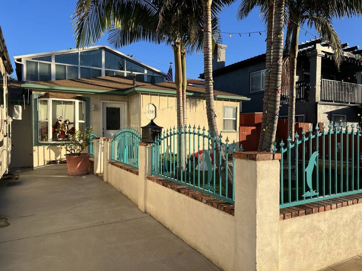 Ornamental teal fence and gate with dolphin accents