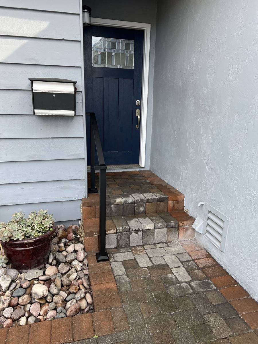 Single black handrail at a front entry